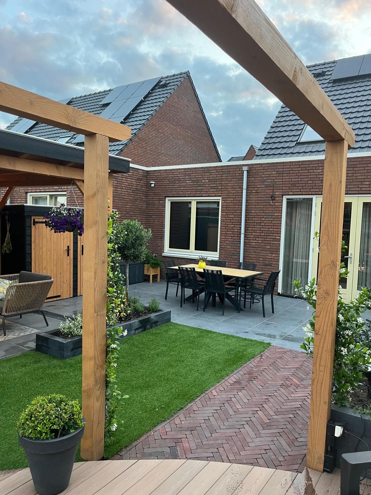 Verzorgde tuin met gazon, border en zitje onder bomen